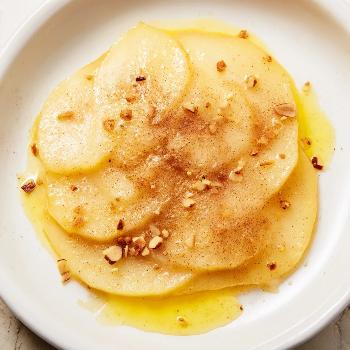 Close-up of a Rustic Crustless Apple Pie; the apples gleam under a sweet, golden baked top.