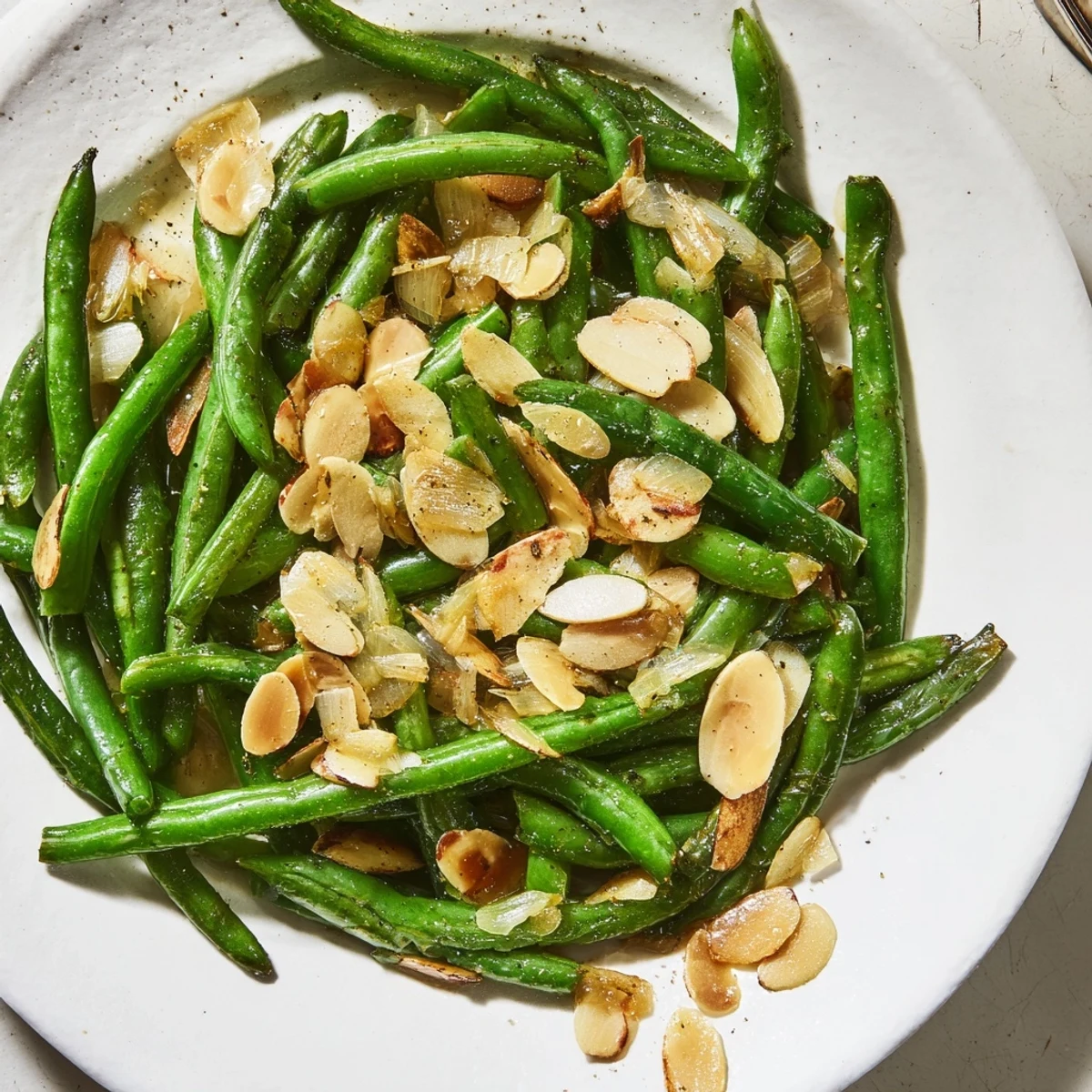 Sautéed green beans with garlic and almonds, tossed in olive oil, a quick, flavorful side.