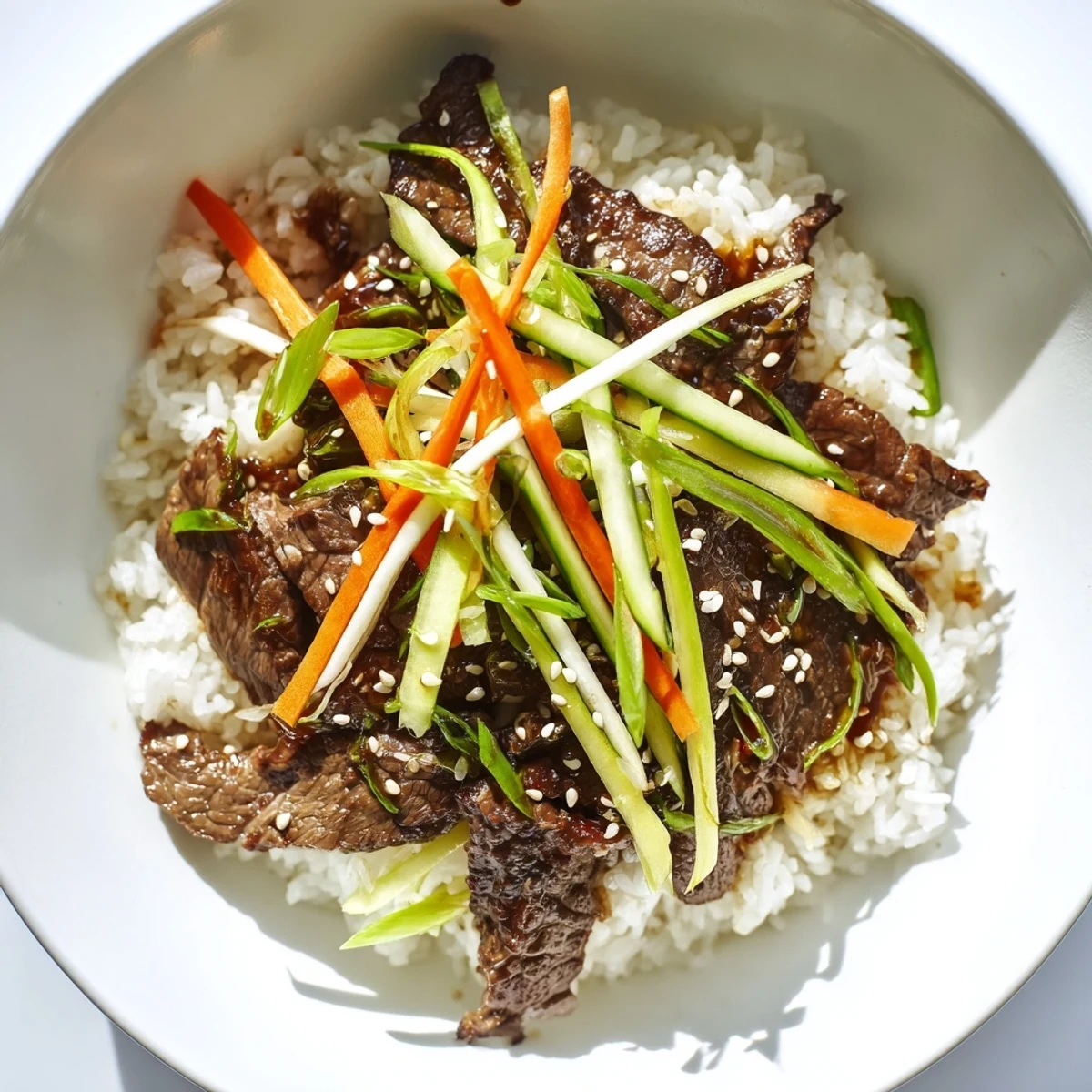 A beautifully arranged bulgogi beef bowl featuring succulent beef, fresh veggies, and aromatic sesame seeds, a true delight.