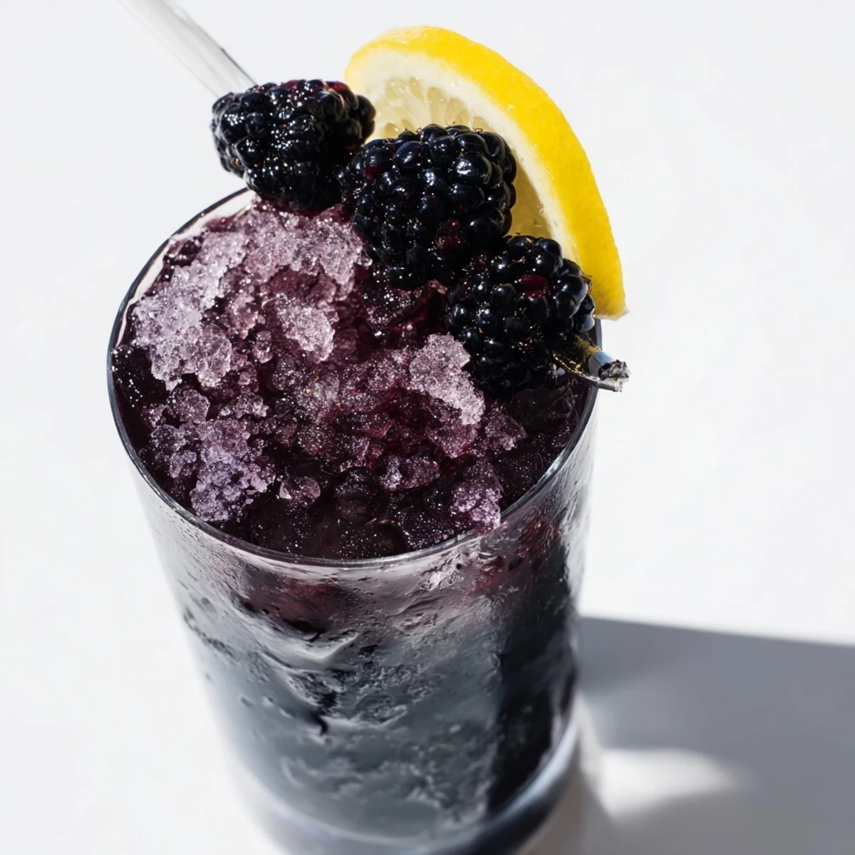 Dark Matter Mocktail, a layered, jet-black drink topped with fresh blackberries and citrus slices.