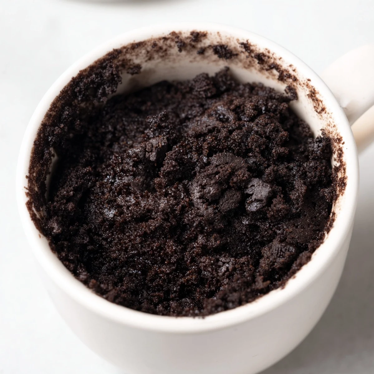 Steaming Oreo mug cake, a quick chocolate dessert topped with whipped cream, ready to enjoy.