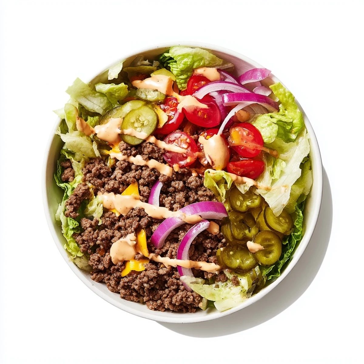 This hearty gluten-free Big Mac bowl features crisp lettuce, cheddar cheese, tomatoes, pickles, and homemade special sauce.  