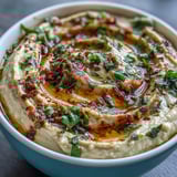 Vibrant bowl of Black-Eyed Pea Hummus garnished with olive oil and sumac, perfect for a healthy vegan appetizer platter.