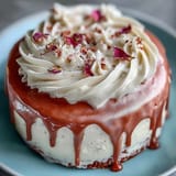 Moist rosé velvet cake with smooth cream cheese frosting and shimmering gold accents.