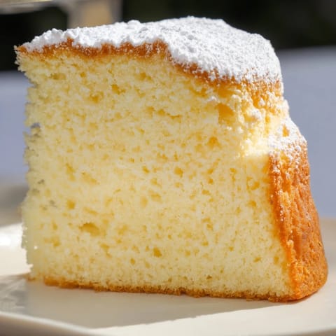 Freshly baked 3-Ingredient Vanilla Sponge Cake, golden brown and ready for serving with berries.
