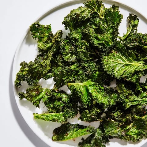 Golden, flaky Crispy Kale Chips fresh from the oven, offering a satisfying crunch.