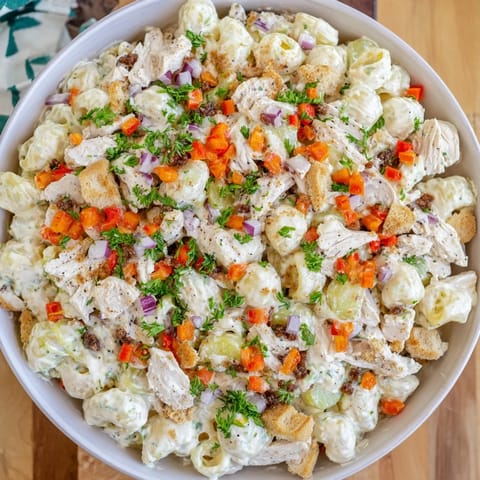 A refreshing bowl of Chicken Macaroni Holiday Salad, filled with chilled macaroni and creamy dressing.