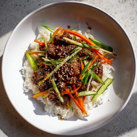 Golden-brown bulgogi beef slices sit atop fluffy rice, showcasing this sweet and savory Korean bowl.