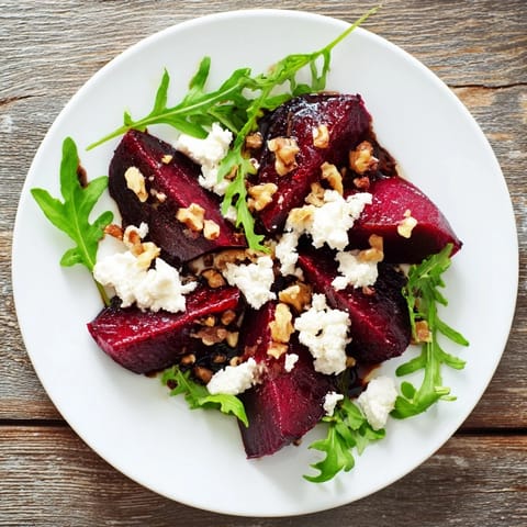 Sliced roasted beets and creamy goat cheese crumbles over peppery arugula with toasted walnuts in this salad.
