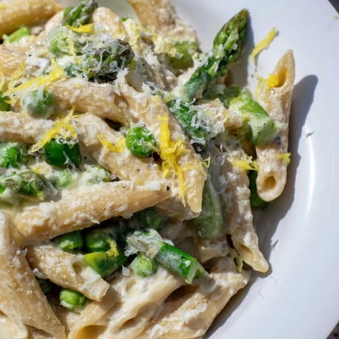 Hearty bowl of Garlic Parmesan Spring Vegetable Pasta, featuring crisp-tender veggies and a garlic-infused cream sauce.