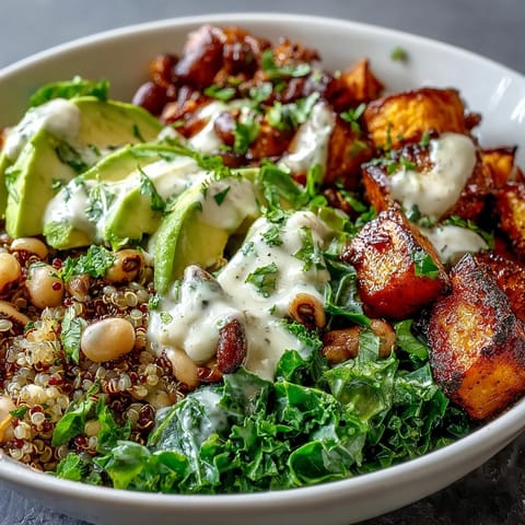 Vibrant Black-Eyed Pea Buddha Bowl with roasted sweet potatoes, red peppers, and creamy tahini dressing, served over fluffy quinoa.