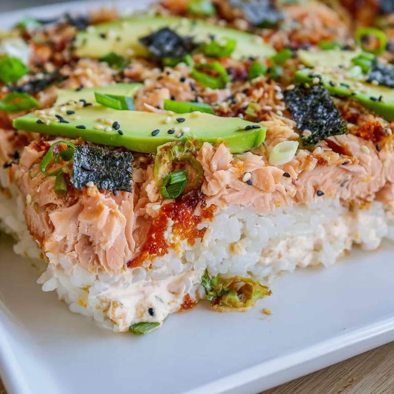 This baked family-style Sushi Bake Casserole features flaked salmon over seasoned rice, ready to enjoy.