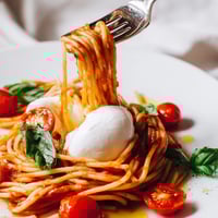 Freshly torn burrata cheese melts into warm, al dente spaghetti tossed with juicy cherry tomatoes and fragrant basil. A vibrant and comforting Burrata Caprese Pasta ready to serve.