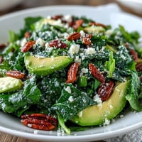Bright lemon vinaigrette arugula salad with shaved Parmesan, toasted pine nuts, and fresh greens in a serving bowl.