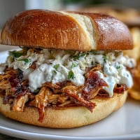 Smoked pulled chicken sandwiches with creamy white BBQ sauce, a Southern delight.